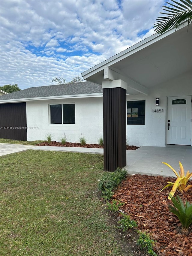 entrance to property featuring a yard