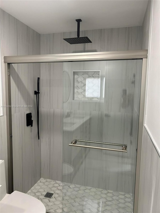 bathroom featuring an enclosed shower and toilet