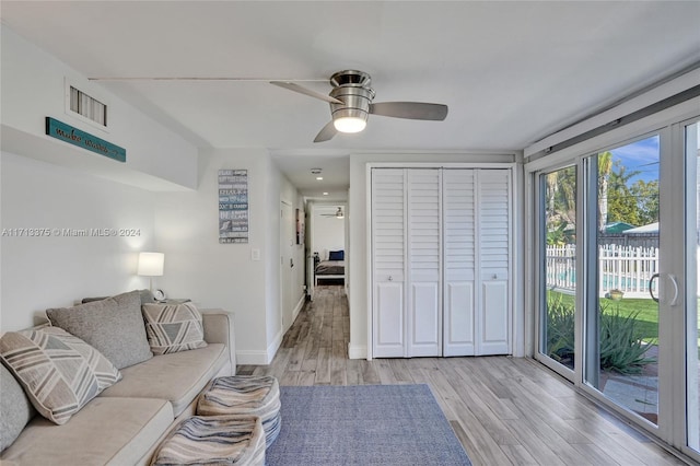 living room with ceiling fan and light wood-type flooring