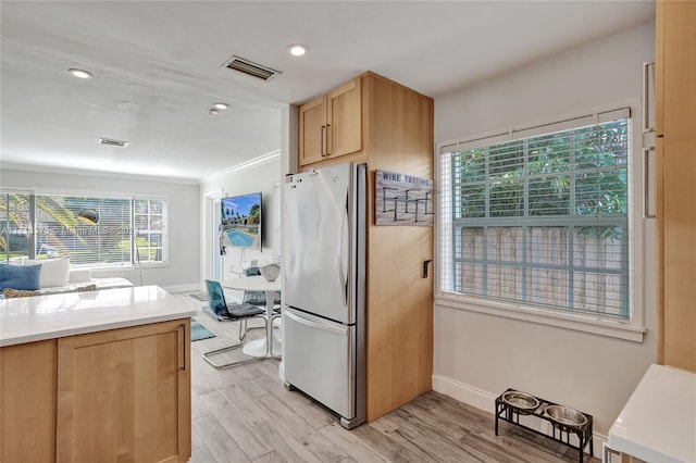 kitchen with stainless steel refrigerator and light hardwood / wood-style floors