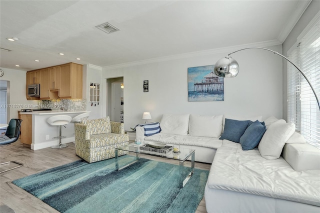 living room with light hardwood / wood-style floors and crown molding