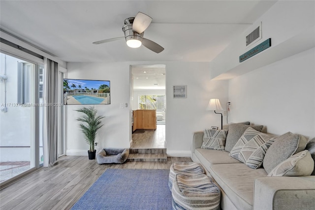 living room with ceiling fan and light hardwood / wood-style flooring