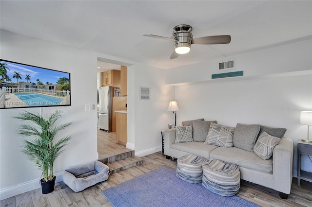 living room featuring wood-type flooring and ceiling fan