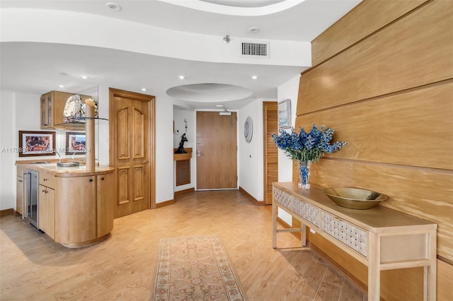 hall with wine cooler and light wood-type flooring