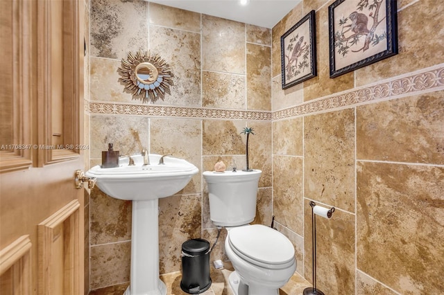 bathroom featuring tile walls and toilet