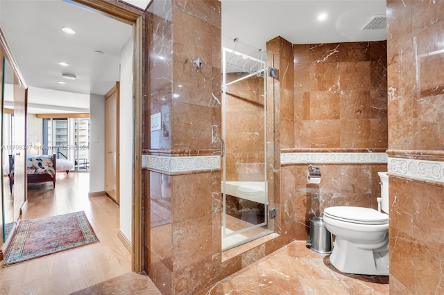 bathroom featuring tile walls and toilet