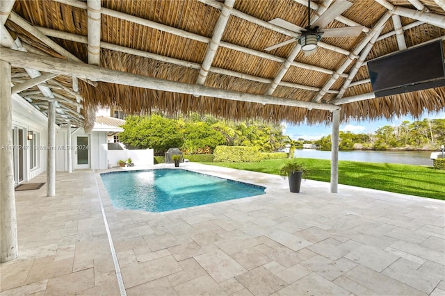 view of pool with a gazebo, ceiling fan, a water view, and a patio