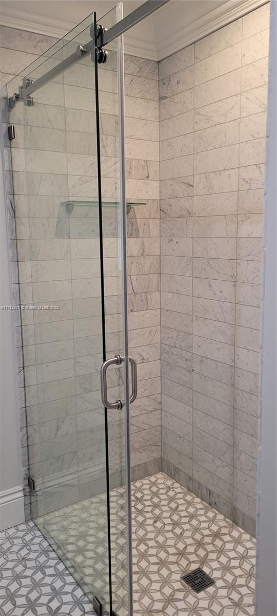 bathroom featuring walk in shower and ornamental molding