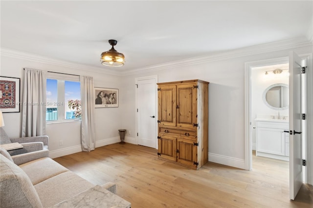 sitting room with ornamental molding, sink, and light hardwood / wood-style flooring