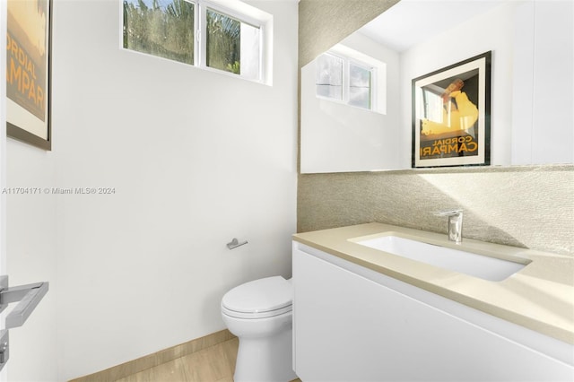 bathroom with tile patterned floors, vanity, toilet, and tasteful backsplash