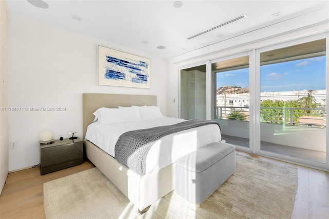 bedroom with access to exterior and light hardwood / wood-style floors