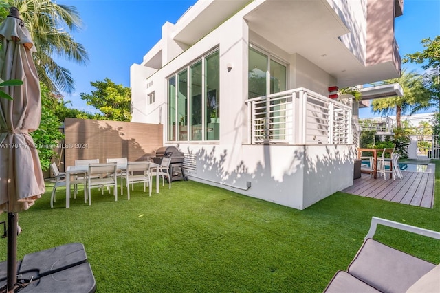 rear view of house with a yard and a deck