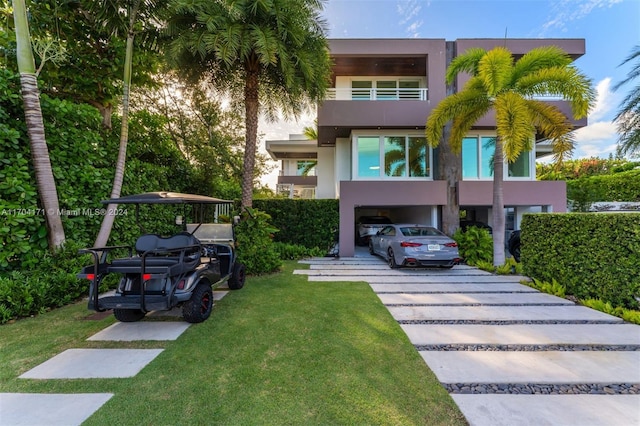 view of front of property featuring a front lawn and a carport