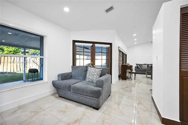 living room featuring plenty of natural light, lofted ceiling, and french doors