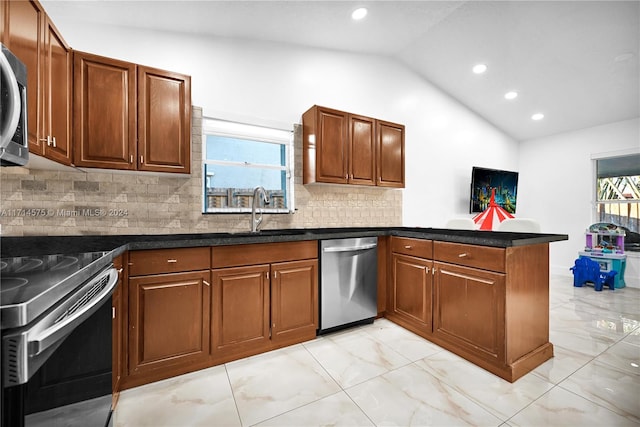 kitchen featuring kitchen peninsula, appliances with stainless steel finishes, decorative backsplash, sink, and lofted ceiling