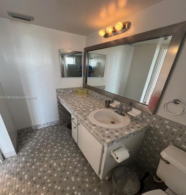 bathroom featuring tile patterned flooring, vanity, and toilet