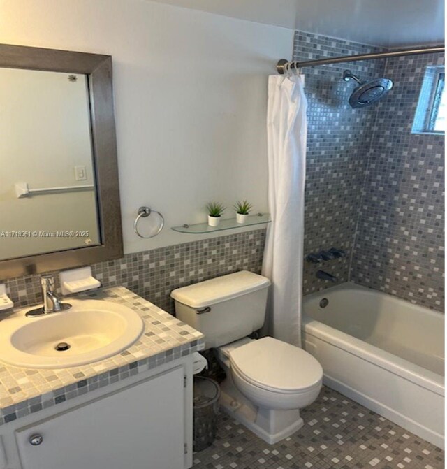 full bathroom featuring vanity, decorative backsplash, tile patterned floors, toilet, and shower / bath combo with shower curtain