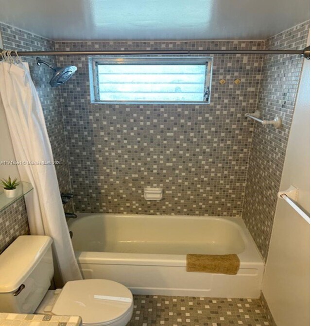 bathroom featuring tile patterned flooring, shower / tub combo, and toilet