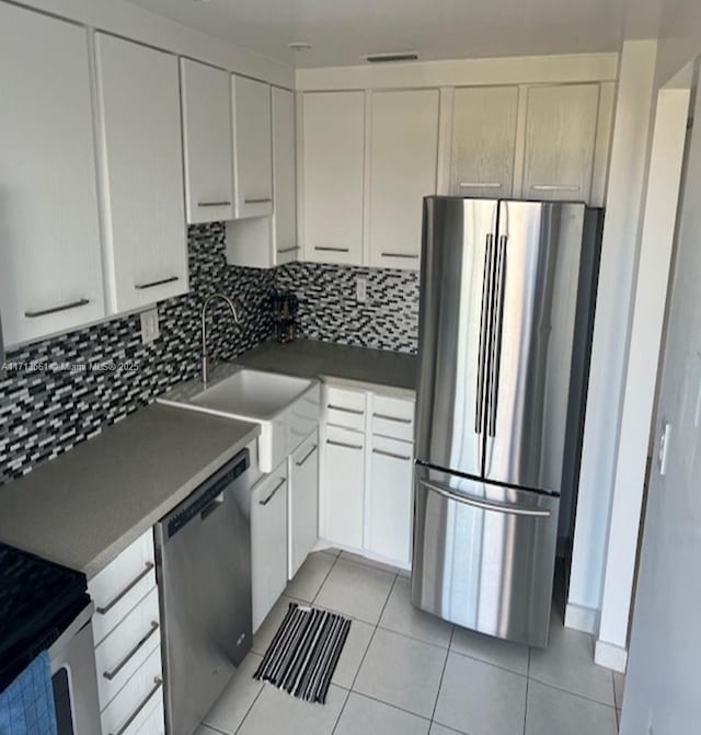 kitchen featuring stainless steel appliances, tasteful backsplash, sink, and white cabinets