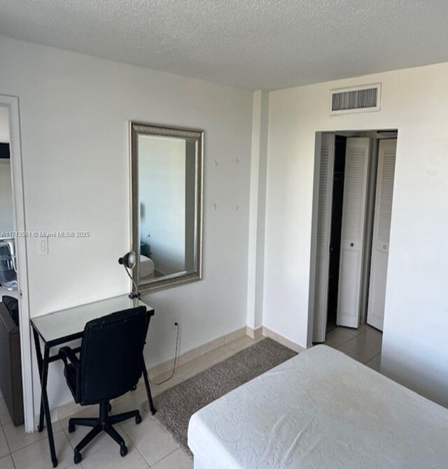 tiled bedroom with a textured ceiling