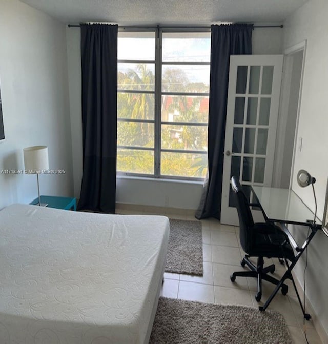 bedroom featuring light tile patterned floors and a textured ceiling