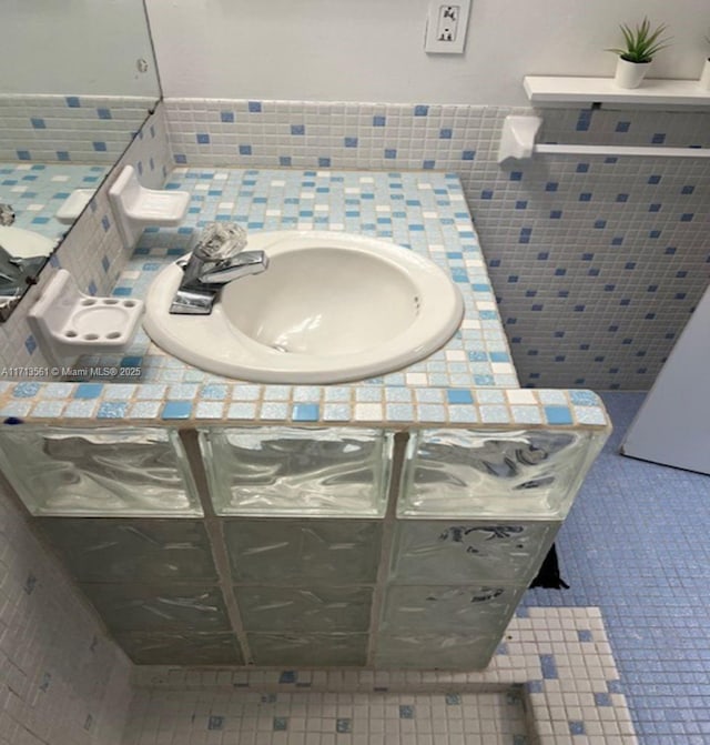 bathroom featuring tile patterned floors, sink, and tile walls