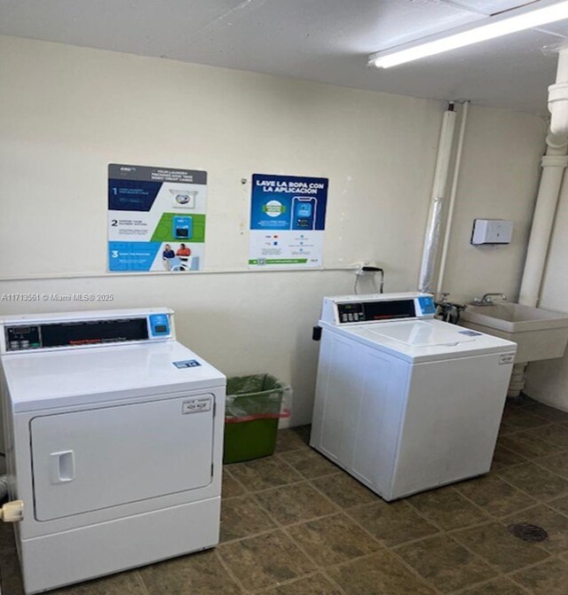 clothes washing area with separate washer and dryer and sink