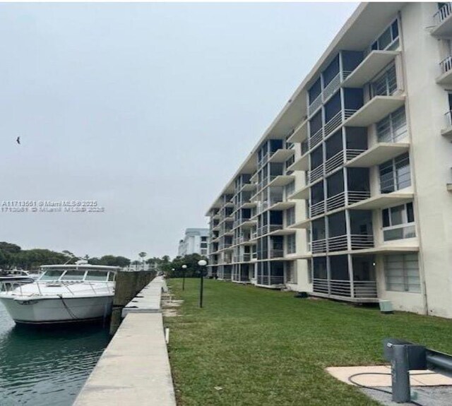 view of dock featuring a water view and a lawn