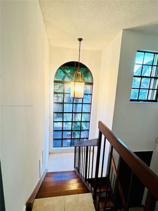 staircase with a textured ceiling