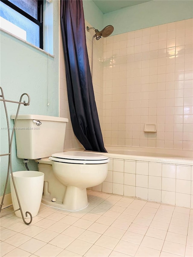 bathroom with tiled shower / bath, toilet, and tile patterned floors