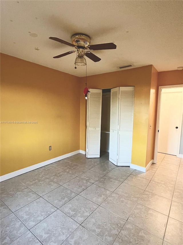 unfurnished bedroom with baseboards, a textured ceiling, visible vents, and a closet