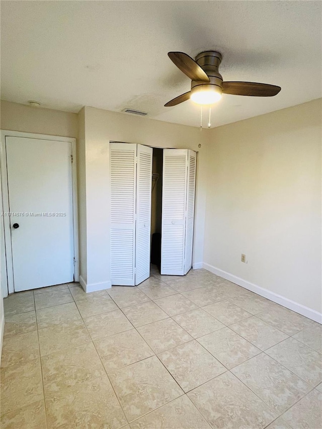 unfurnished bedroom with light tile patterned floors, a closet, and baseboards