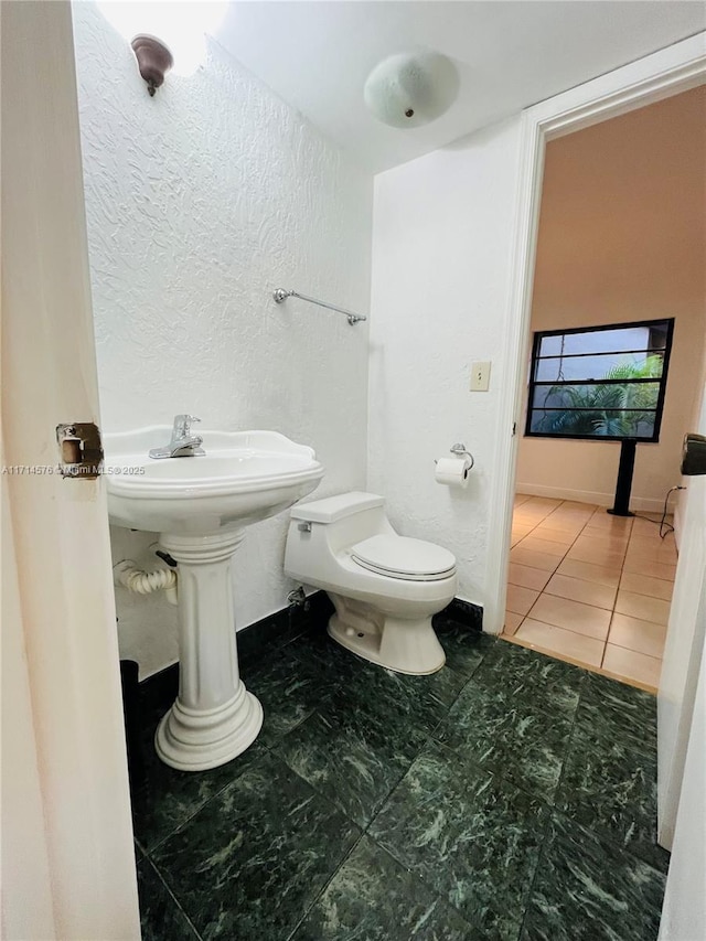 half bath with toilet and tile patterned flooring