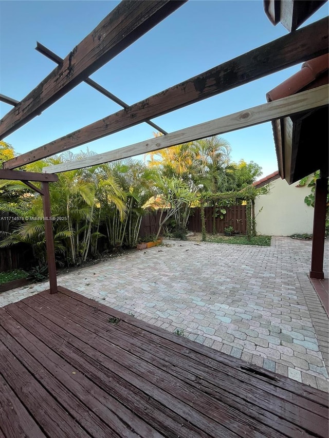 wooden terrace featuring fence and a patio