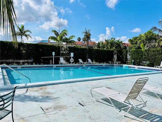 pool with a patio and fence