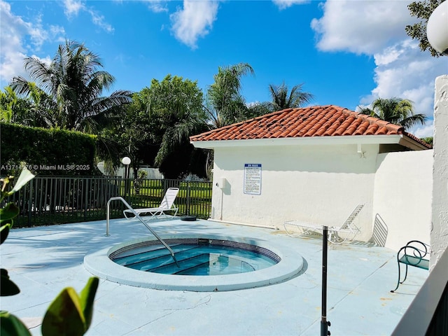 view of swimming pool featuring a patio area, fence, and a hot tub