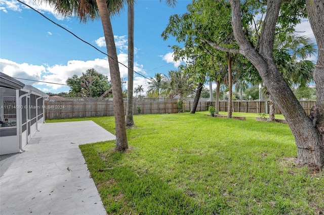 view of yard featuring a sunroom and a patio