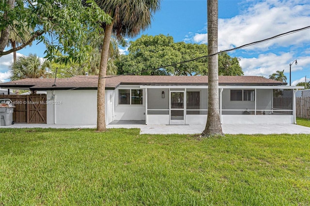 back of property with a sunroom and a yard