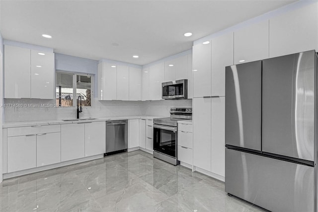 kitchen with white cabinets, appliances with stainless steel finishes, tasteful backsplash, and sink