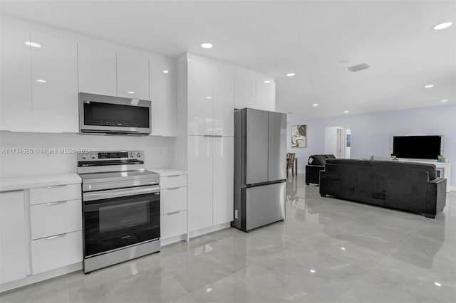 kitchen with white cabinets and appliances with stainless steel finishes