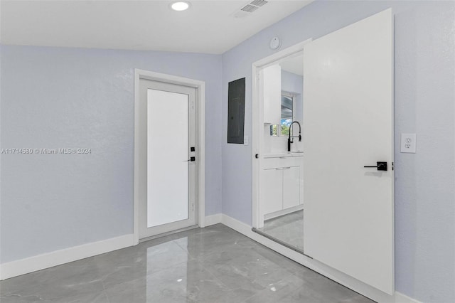 corridor with lofted ceiling, sink, and electric panel