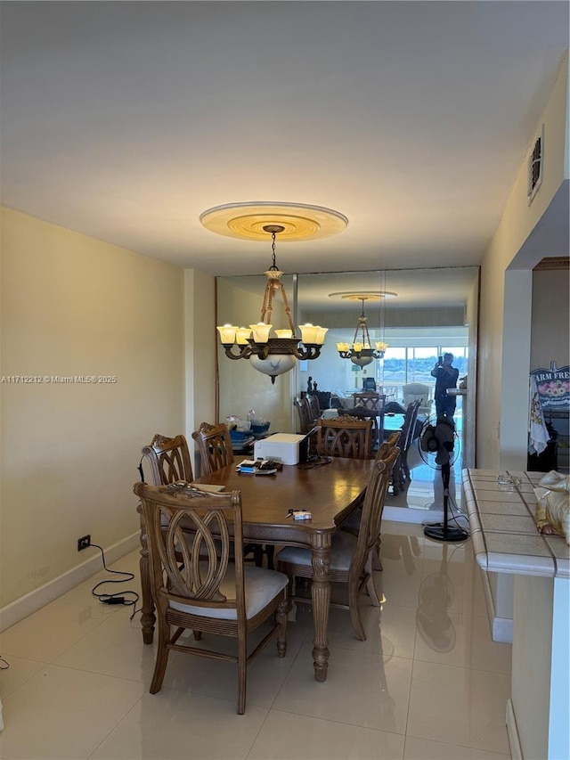 tiled dining room featuring a notable chandelier