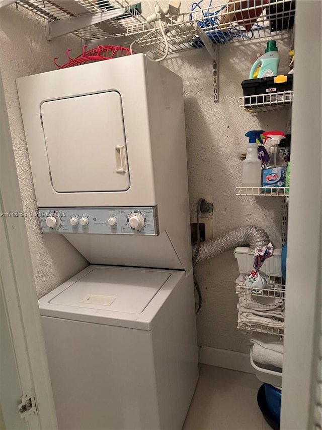 clothes washing area with stacked washer / dryer