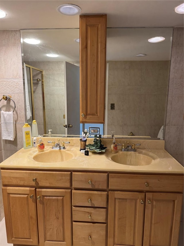 bathroom featuring tiled shower and vanity