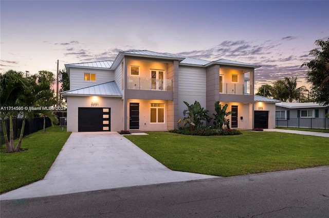 contemporary house with a yard, a balcony, and a garage