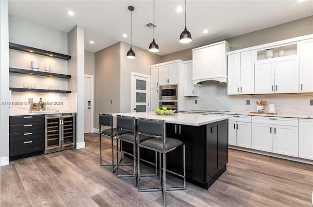 kitchen featuring white cabinets, beverage cooler, and appliances with stainless steel finishes