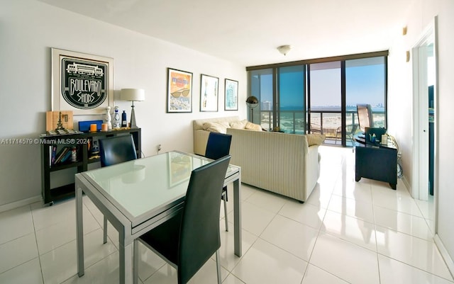 dining space featuring expansive windows and light tile patterned flooring