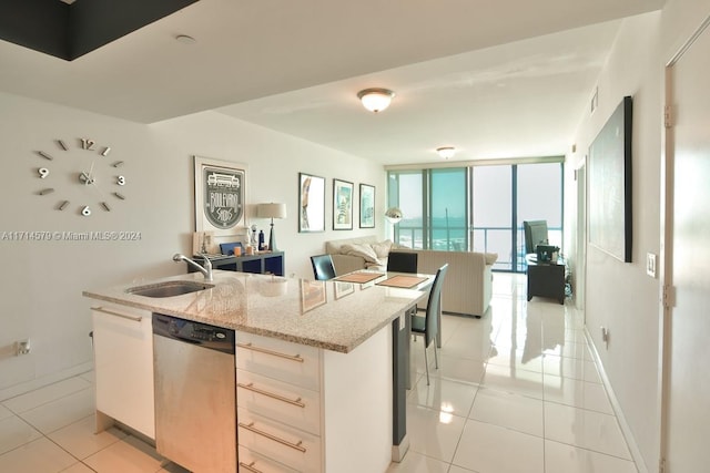 kitchen with floor to ceiling windows, white cabinetry, dishwasher, light stone countertops, and sink