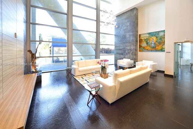 living room with a towering ceiling, a wall of windows, and a healthy amount of sunlight