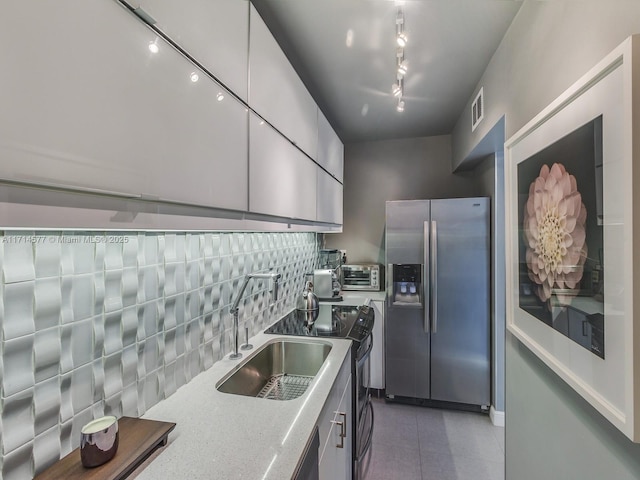 kitchen featuring tasteful backsplash, rail lighting, sink, white cabinetry, and stainless steel fridge with ice dispenser